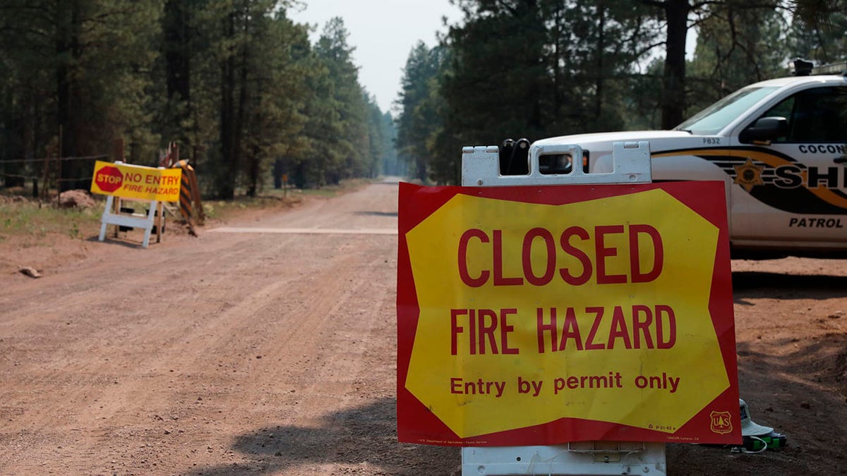The Coconino County Sheriff's Office blocks off a U.S. Forest Service Road outside of Flagstaff, Ariz., on Monday, June 21, 2021. Dozens of wildfires were burning in hot, dry conditions across the U.S. West, including a blaze touched off by lightning that was moving toward northern Arizona's largest city. (Brady Wheeler/Arizona Daily Sun via AP)