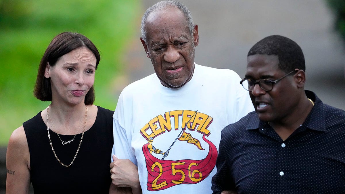 Comedian Bill Cosby, center, and spokesperson Andrew Wyatt, right, approach members of the media gathered outside Cosby's home in Elkins Park, Pa., Wednesday, June 30, 2021, after Pennsylvania's highest court overturned his sex assault conviction. 