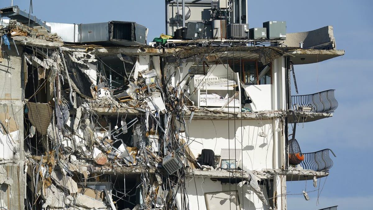 Furniture sits perched in the remains of apartments sheared in half, in the still standing portion of the Champlain Towers South condo building, more than a week after it partially collapsed, Friday, July 2, 2021, in Surfside, Fla. (AP Photo/Mark Humphrey)