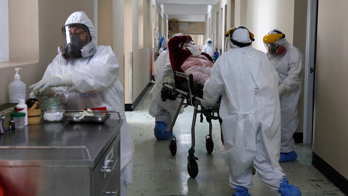 FILE - In this June 25, 2021, file photo, medical staff transport a COVID-19 patient at the Honorio Delgado Hospital in Arequipa, Peru. The global death toll from COVID-19 has eclipsed 4 million as the crisis increasingly becomes a race between the vaccine and the highly contagious delta variant. (AP Photo/Guadalupe Pardo, File)