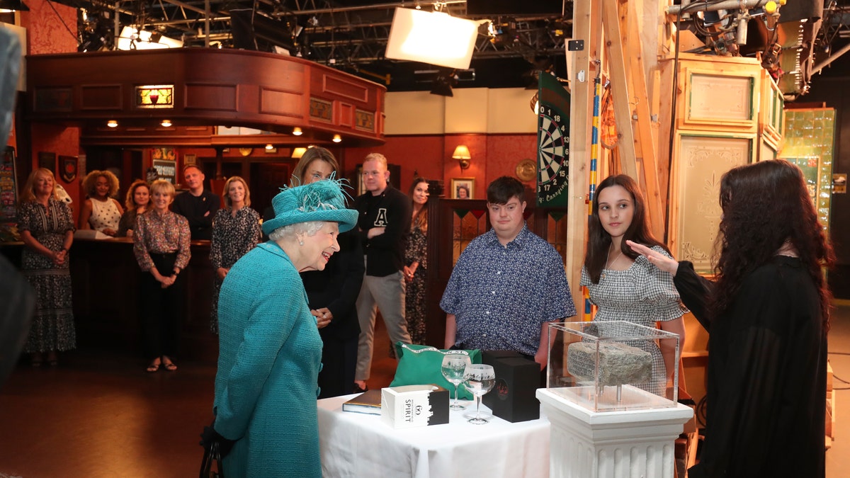 Britain's Queen Elizabeth II meets actors and members of the production team during a visit to the set of the long running television series Coronation Street, in Manchester, England, Thursday July 8, 2021.