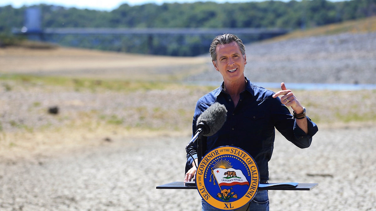 FILE — In this April 21, 2021, file photo California Gov. Gavin Newsom speaks at a news conference in the parched basin of Lake Mendocino in Ukiah, Calif., where he announced he would proclaim a drought emergency for Mendocino and Sonoma counties. On Thursday July 8, 2021, Newsom asked people to voluntarily reduce their water use by 15% in the middle of the drought. He also added nine more counties to the state's emergency proclamation. (Kent Porter/The Press Democrat via AP, File)