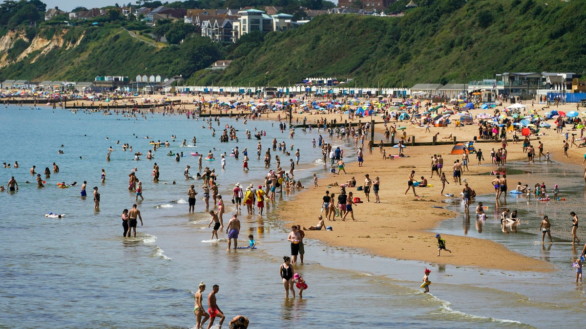 People enjoy the weather on Bournemouth beach in Dorset, England, Monday July 19, 2021. (Steve Parsons/PA via AP)