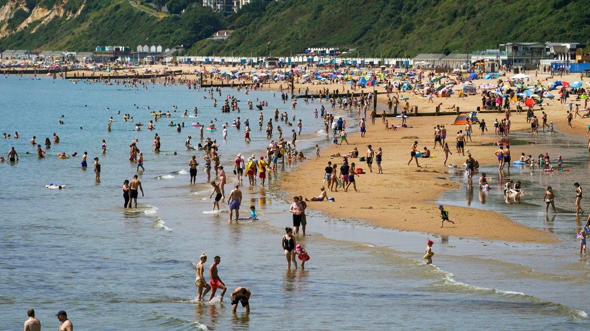 People enjoy the weather on Bournemouth beach in Dorset, England, Monday July 19, 2021. (Steve Parsons/PA via AP)
