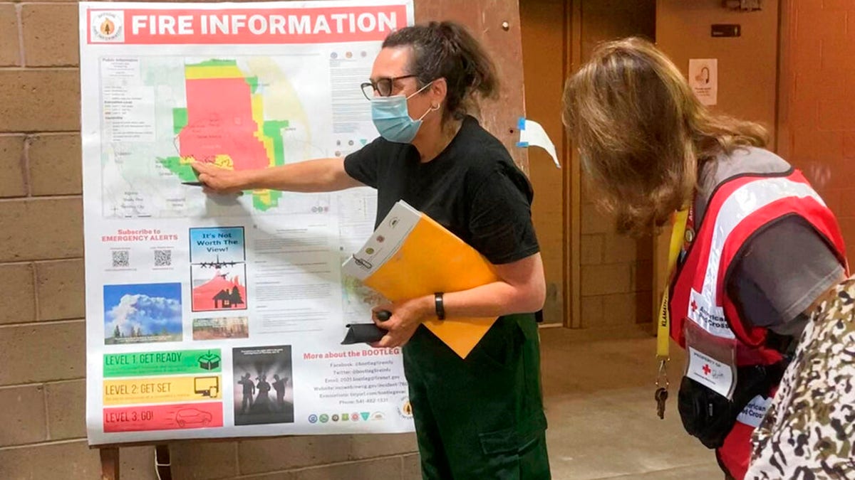 In this photo provided by the Bootleg Fire Incident Command, a public information officer talks with evacuees at a Red Cross Shelter near the Bootleg Fire in southern Oregon, Sunday, July 18, 2021. (Bootleg Fire Incident Command via AP)