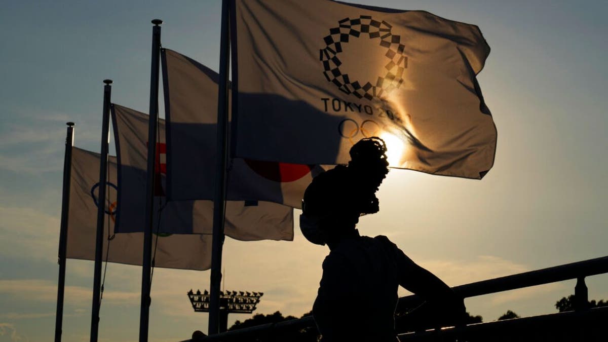 Tokyo Olympics flag with a person standing in front