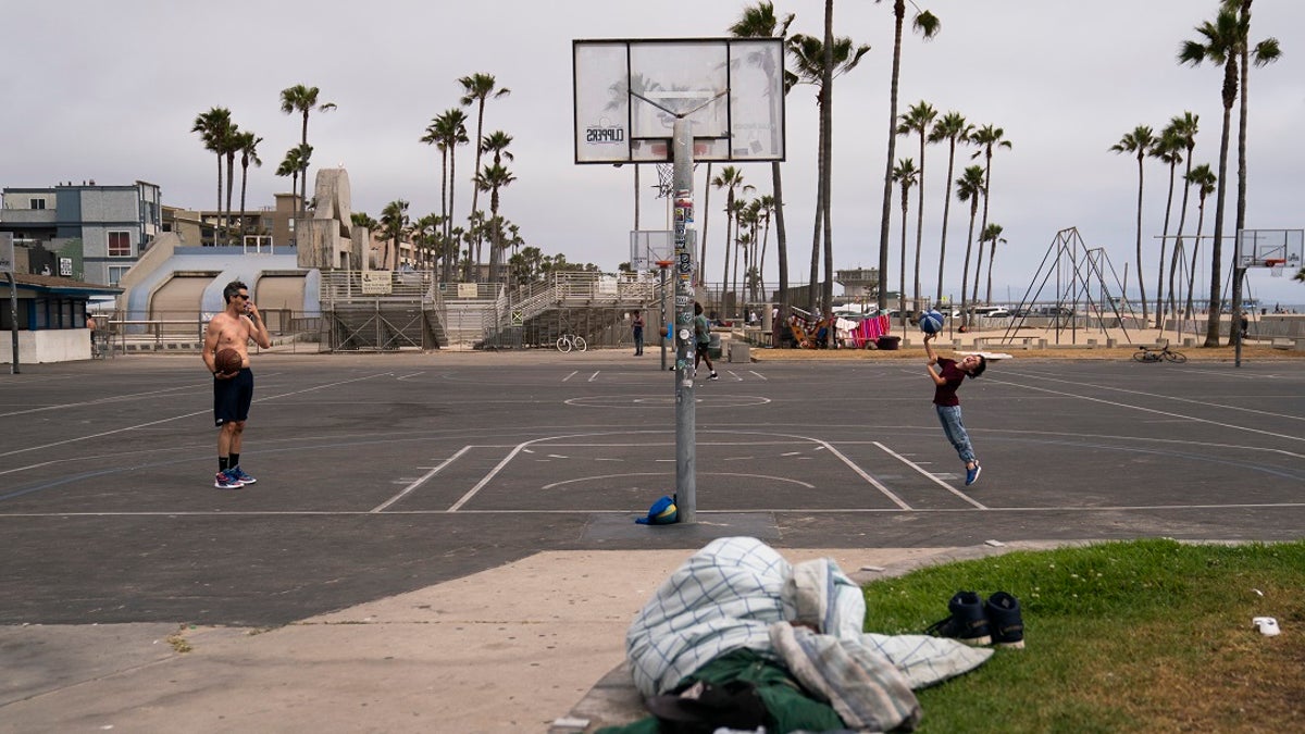 A homeless person on the ground in Venice Beach.