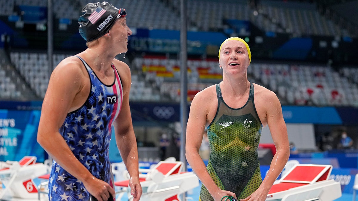 Ariarne Titmus of Australia, right, leaves the pool after winning the final of the women's 400-meters freestyle as Katie Ledecky of the United States watches at the 2020 Summer Olympics, Monday, July 26, 2021, in Tokyo, Japan. (AP Photo/Martin Meissner)