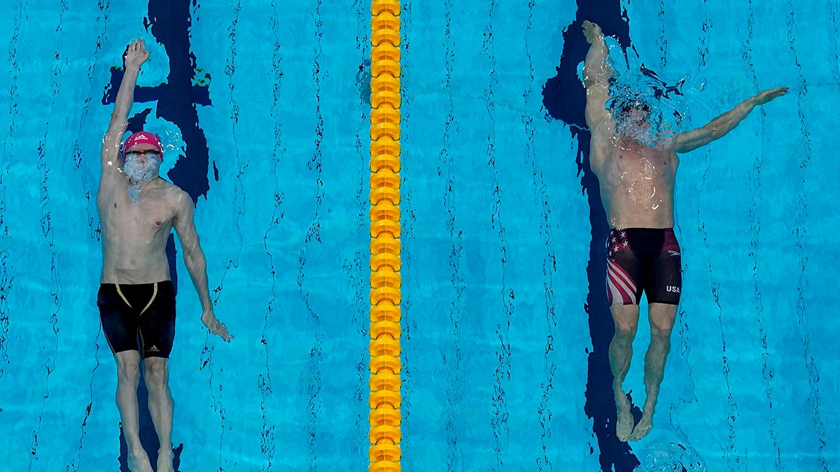 Ryan Murphy, of the United States, and Kliment Kolesnikov, of the Russian Olympic Committee, swim in the final of the men's 100-meter backstroke final at the 2020 Summer Olympics, Tuesday, July 27, 2021, in Tokyo, Japan. (AP Photo/Morry Gash)