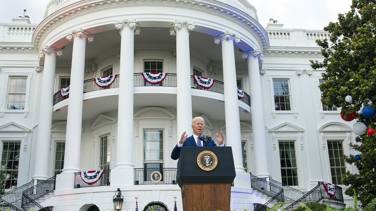 President Biden stands behind a podium and gives speech on White House lawn