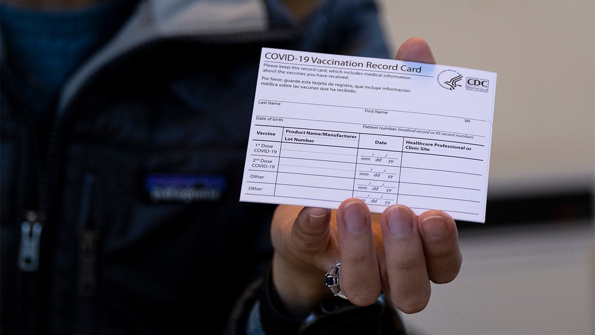 Sarah Gonzalez, a nurse practitioner from New York, displays a COVID-19 vaccine card at a New York Health and Hospitals vaccine clinic in the Brooklyn