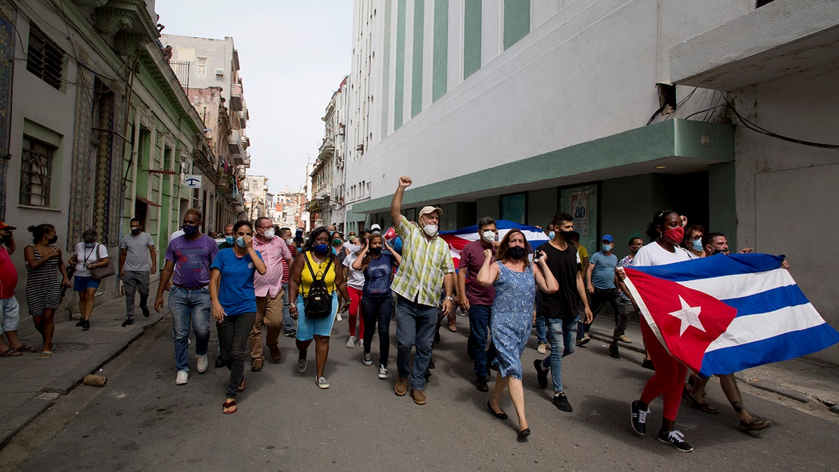 Backers of the government march in Havana, Cuba, Sunday, July 11, 2021. Hundreds of supporters of the government took to the streets while hundreds protested against ongoing food shortages and high prices of foodstuffs. (AP Photo/Ismael Francisco)
