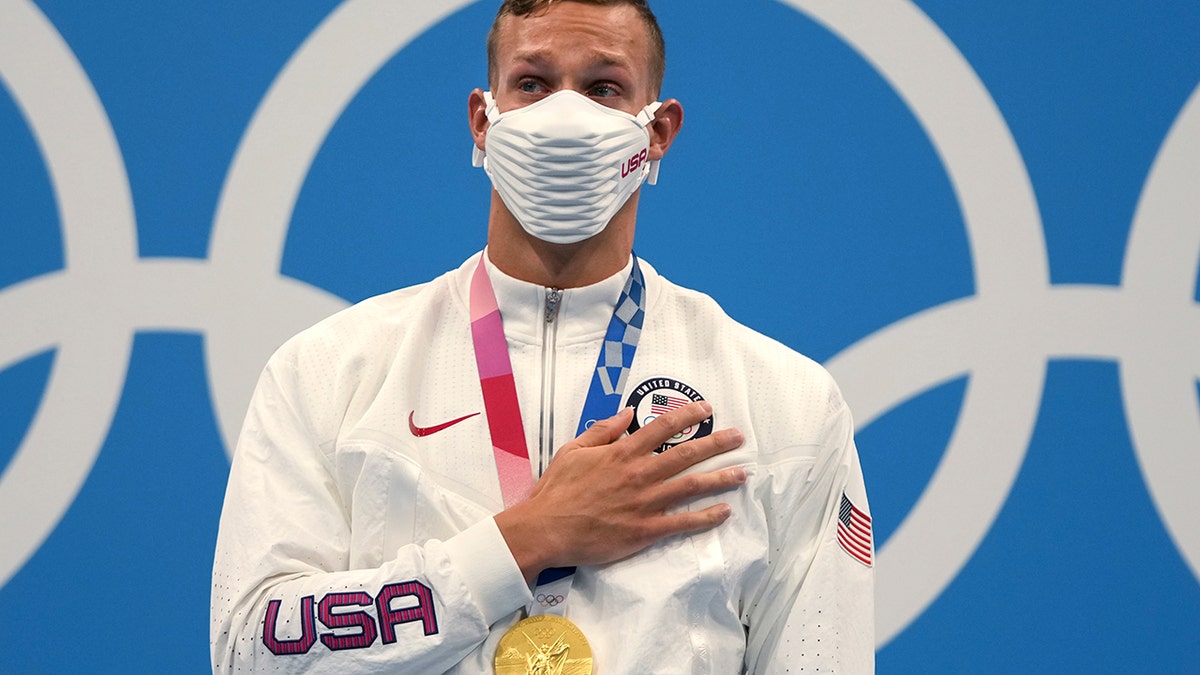 Caeleb Dressel of the United States stands on the podium after receiving his gold medal for the men's 100-meter freestyle at the 2020 Summer Olympics