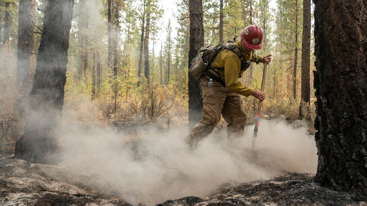 Firefighter Garrett Suza, with the Chiloquin Forest Service, mops up a hot spot on the North East side of the Bootleg Fire, Wednesday, July 14, 2021, near Sprague River, Ore. (AP)