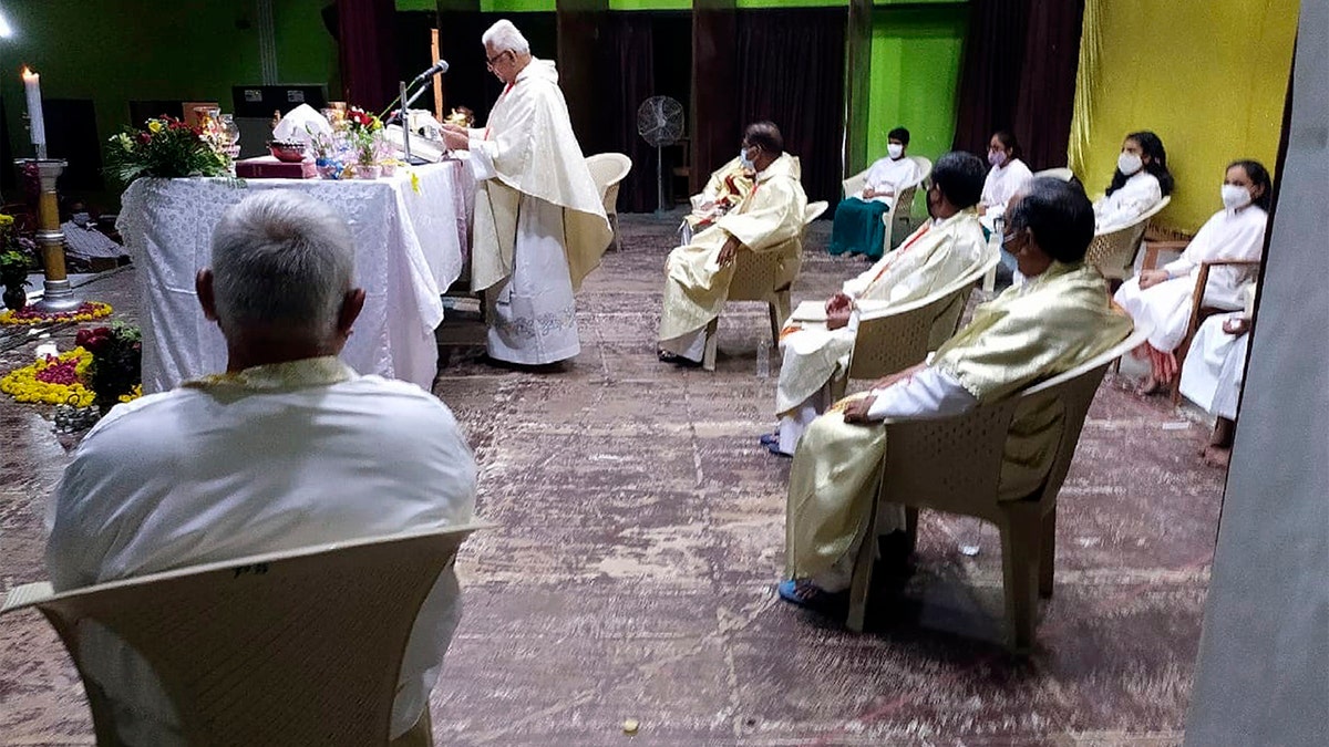 In this photo provided by the Rev. Cedric Prakash, the Rev. Jerry Sequeira, standing, preaches at St. Ignatius Loyola church in Ahmedabad, India, shortly before contracting and dying from the coronavirus in April 2021. 