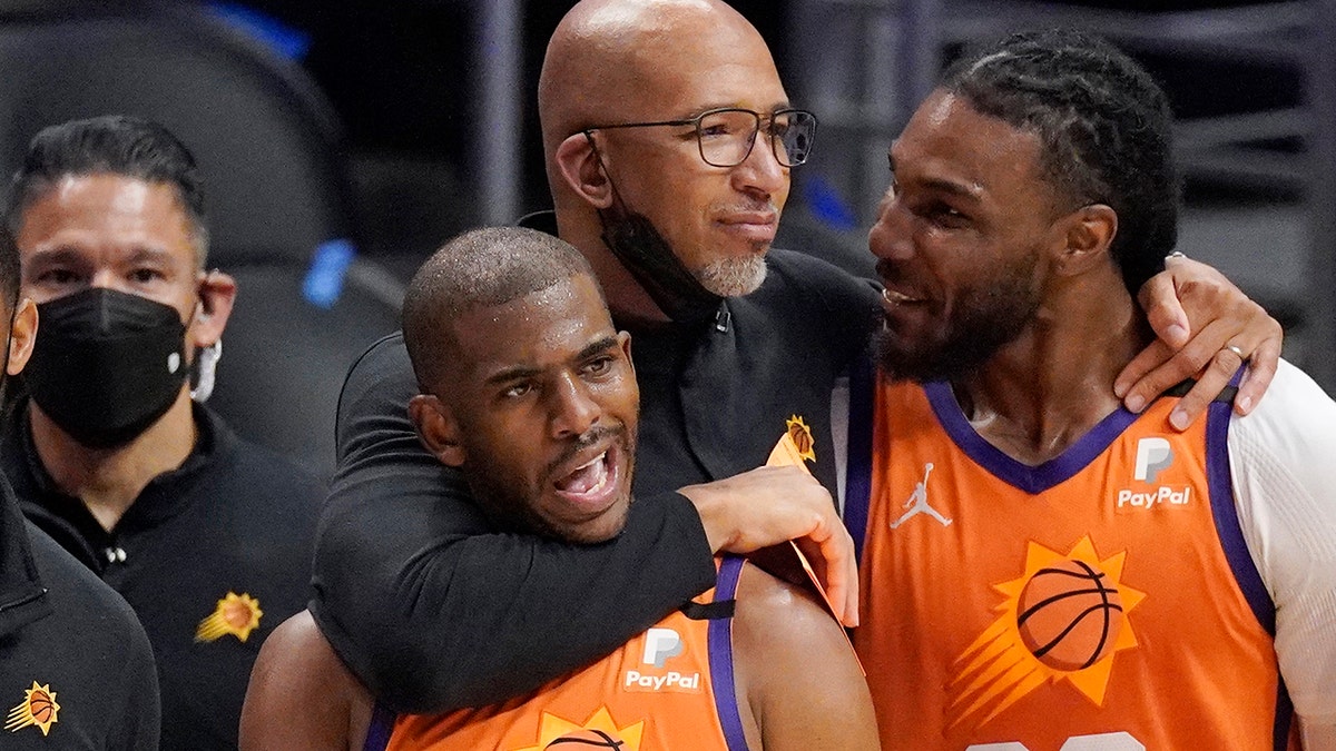 Phoenix Suns head coach Monty Williams hugs Chris Paul, left, and Jae Crowder, second from right, as Devin Booker stands by as time runs out in Game 6 of the NBA basketball Western Conference Finals against the Los Angeles Clippers Wednesday, June 30, 2021, in Los Angeles. 