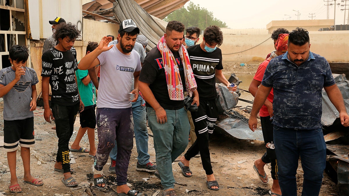 Rescuers and civilians look for bodies after a catastrophic blaze erupted Monday at a coronavirus hospital ward in the al-Hussein Teaching Hospital, in Nasiriyah, Iraq, Tuesday, July 13, 2021. 