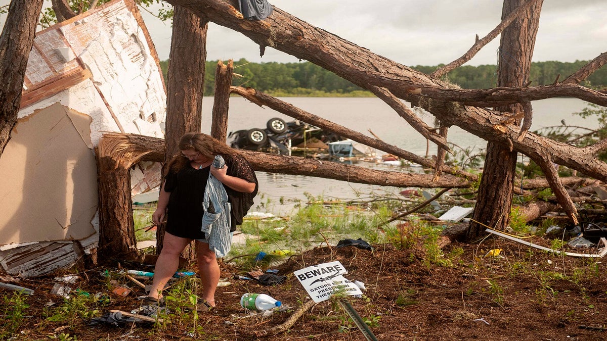 Missy Lattanzie, an RV park resident, searches through her belongings that were destroyed after a tornado touched down Wednesday on Naval Submarine Base Kings Bay, on Thursday in Kings Bay, Ga. Severe weather from Tropical Storm Elsa spurred tornado warnings in Delaware and New Jersey early Friday as the system moved over the mid-Atlantic states and into the northeastern United States. (Mass Communication 3rd Class Aaron Xavier Saldana/U.S. Navy via AP)