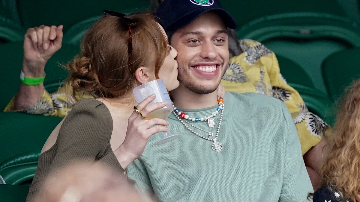 Phoebe Dynevor and Pete Davidson exchange sweet gestures on day 6 of the Wimbledon Tennis Championships at the All England Lawn Tennis and Croquet Club on July 03, 2021 in London. (Photo by Karwai Tang/WireImage)