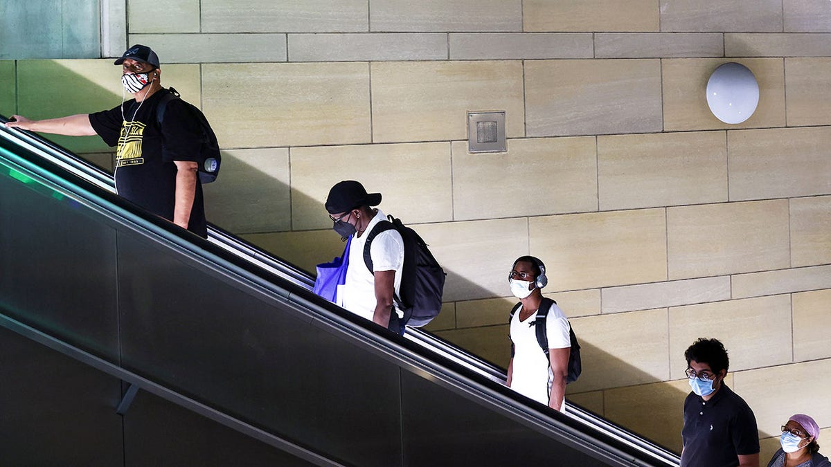 People wear face coverings as they ride an escalator in Union Station in Los Angeles. 