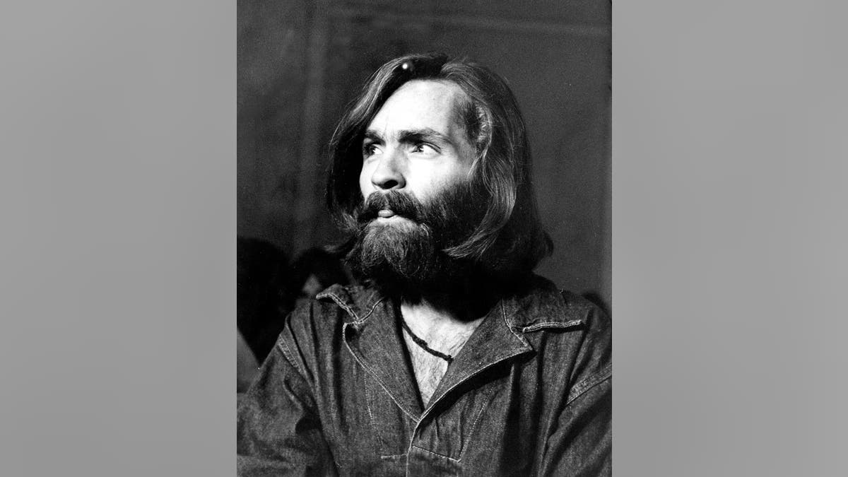 Charles Manson mirando hacia arriba con una camisa vaquera