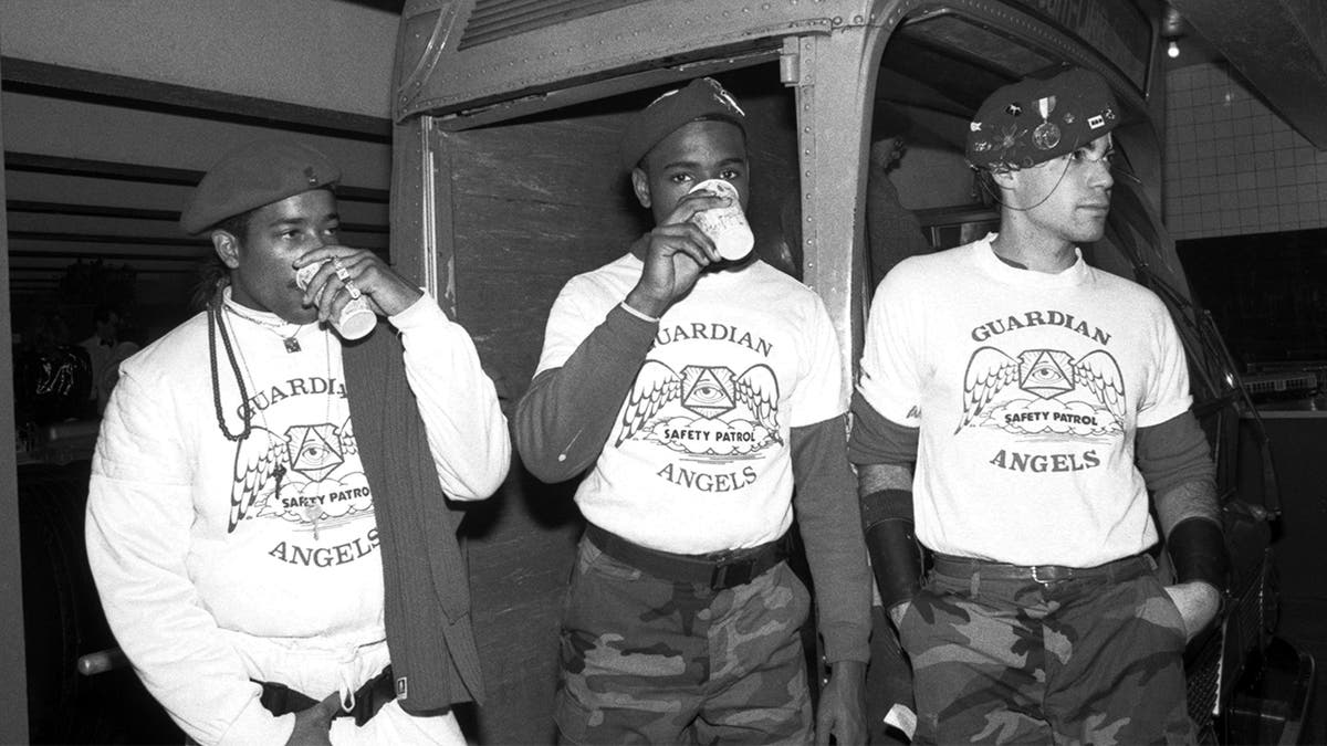 Three unidentified Guardian Angels pose for a photo on November 7, 1987 at an event at which the Guardian Angels present radio personality Howard Stern with an award to thank him for his support at the Boerum Place subway stop in New York City, New York.