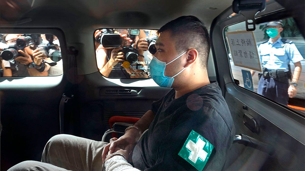 FILE - In this July 6, 2020, file photo, Tong Ying-kit arrives at a court in a police van in Hong Kong. A lawyer for Tong, who convicted under Hong Kong's national security law, asked Thursday, July 29, 2021, for no more than 10 years in prison instead of the possible life sentence faced by the former restaurant waiter in a closely watched case as China tries to crush a pro-democracy movement. (AP Photo/Vincent Yu, File)