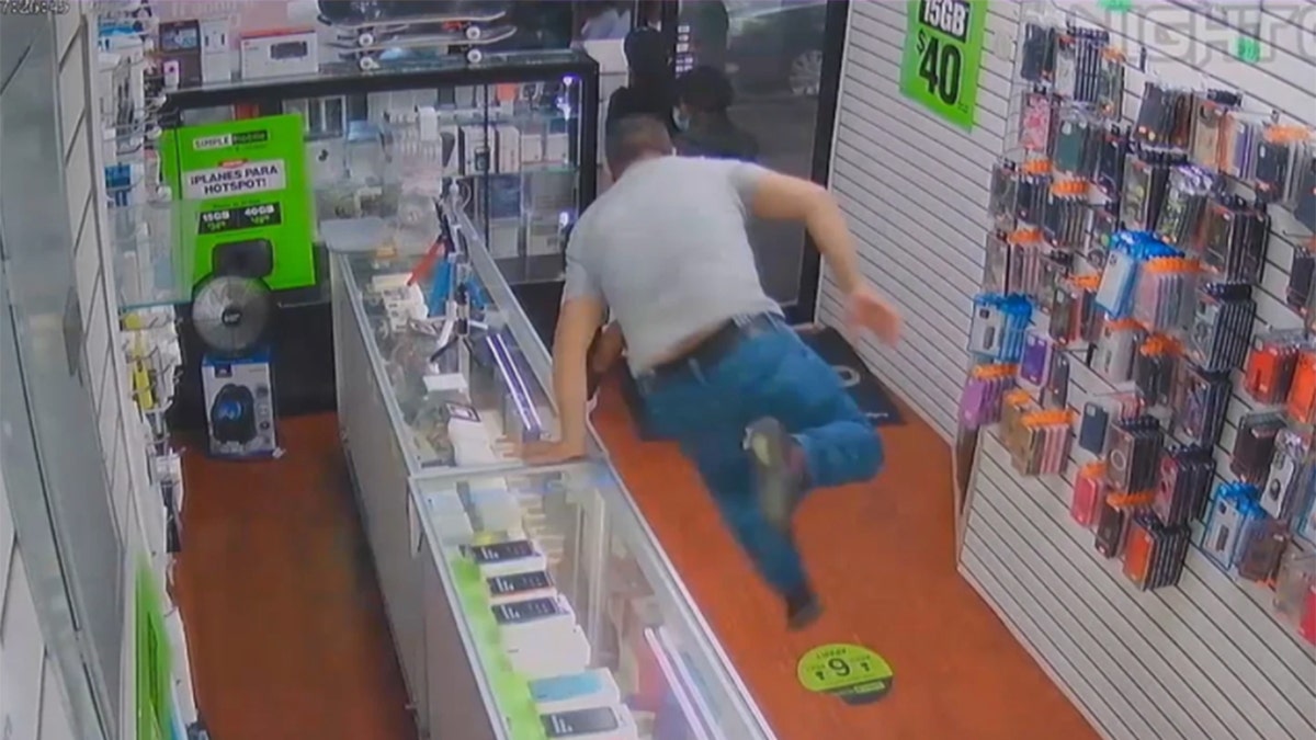 A Queens cellphone store employee jumped over the counter to stop a trio of crooks — and ended up getting robbed himself, according to cops and surveillance video. 