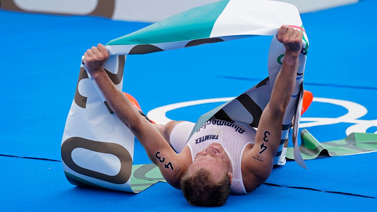 Kristian Blummenfelt of Norway celebrates aafter crossing the finish line to win the gold medal during the men's individual triathlon at the 2020 Summer Olympics, Monday, July 26, 2021, in Tokyo, Japan. (AP Photo/Jae C. Hong)