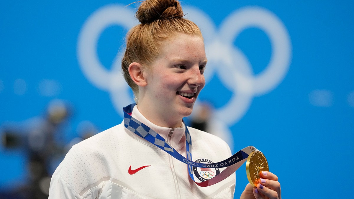 Lydia Jacoby, of the United States, poses with the gold medal after winning the final of the women's 100-meter breaststroke at the 2020 Summer Olympics