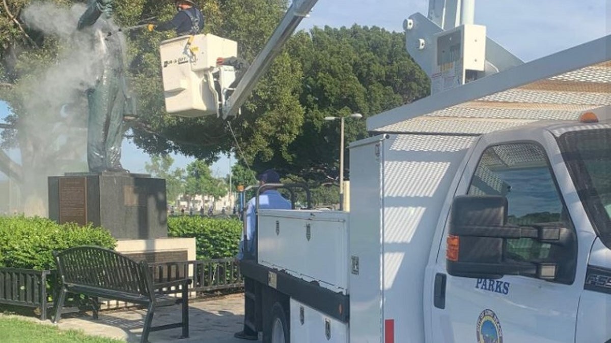 Long Beach city crews clean a statue of Martin Luther King Jr., after it was found vandalized. 