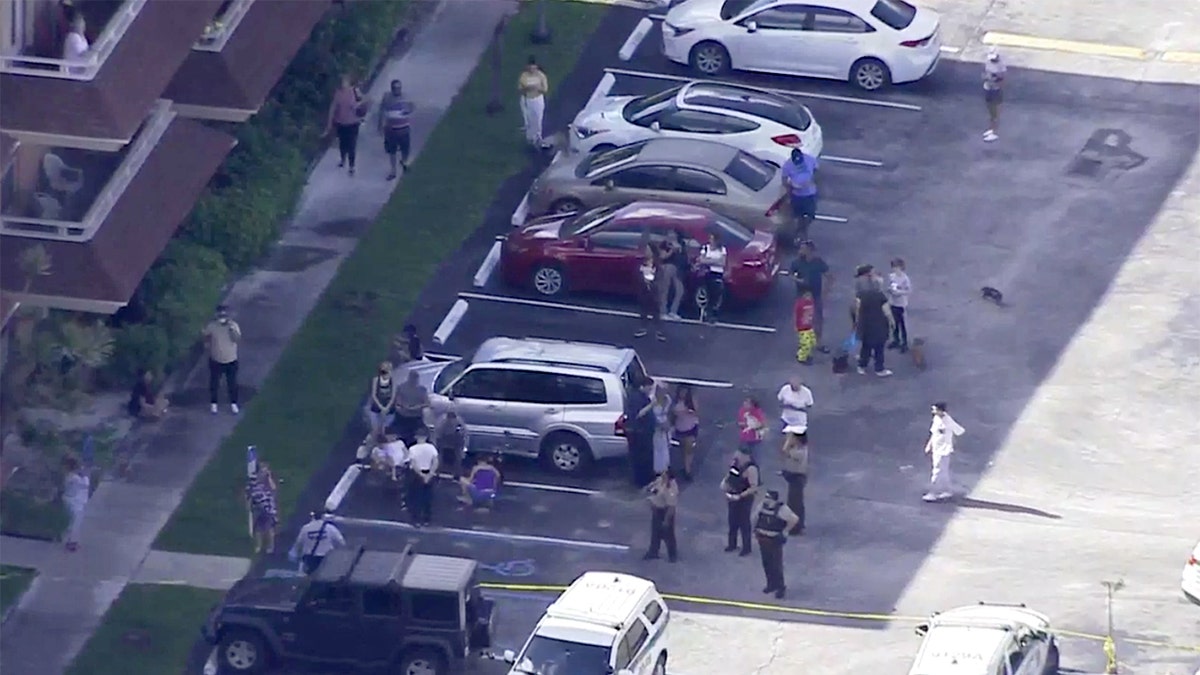 Officers and residents outside the Miami-Dade apartment building where part of the roof broke off and collapsed Thursday afternoon.