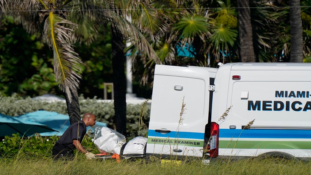 Workers load a stretcher with remains extricated from the rubble into a Miami-Dade County Medical Examiner van, near the Champlain Towers South condo building on Friday. (AP)