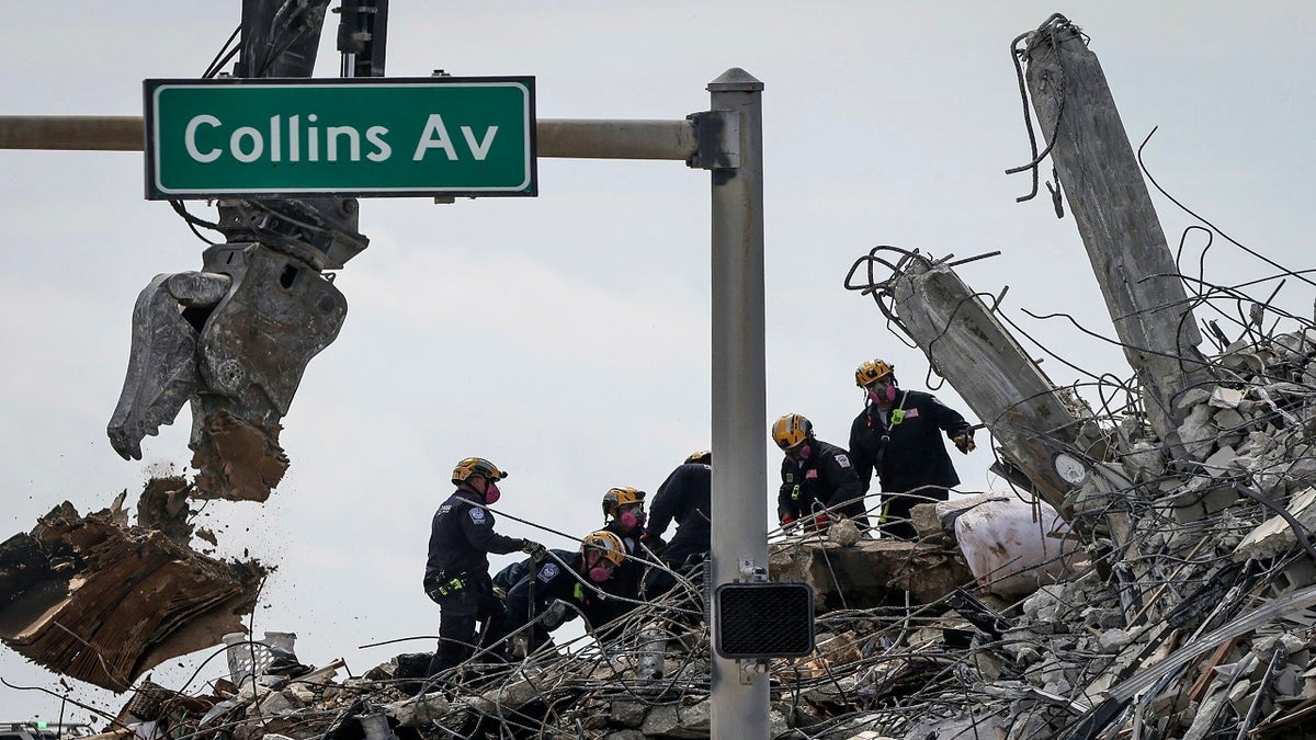 Members of the Pennsylvania Search and Rescue team comb through the debris of the Champlain Tower South complex on Monday. (AP/Miami Herald)