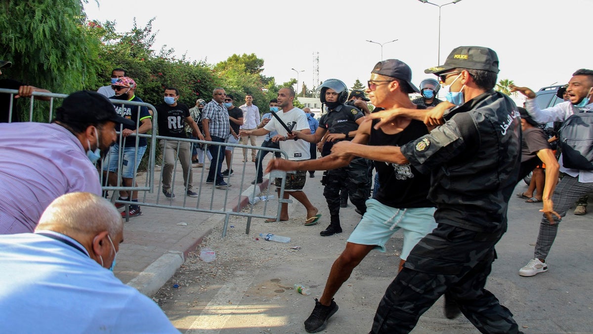 Tunisian police officers scuffle with demonstrators as they gather outside the parliament in Tunis, Tunisia, on Monday. 