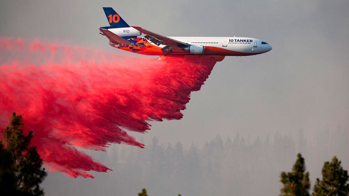 In this photo provided by the Bootleg Fire Incident Command, a DC-10 tanker drops retardant over the Bootleg Fire in southern Oregon, Thursday, July 15, 2021.  (Bootleg Fire Incident Command via AP)