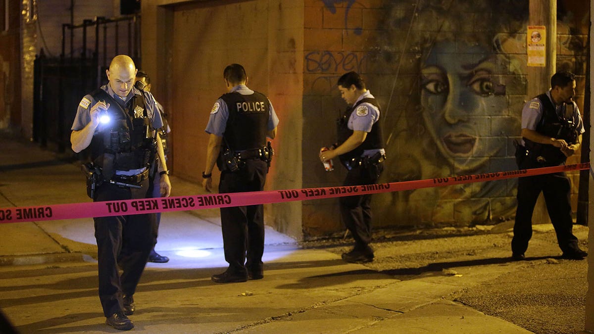 Chicago Police officers investigate the crime scene where a man was shot in the alley in the Little Village neighborhood on July 2, 2017 in Chicago, Illinois.