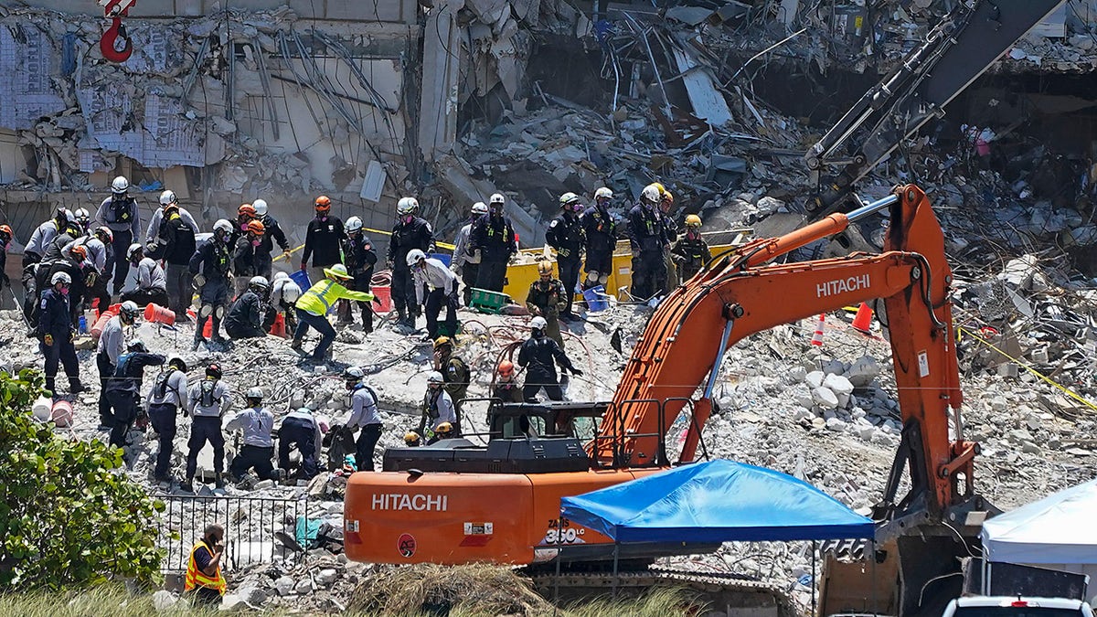 Search and rescue personnel work atop the rubble at the Champlain Towers South condo building, where scores of victims remain missing more than a week after it partially collapsed, Friday, July 2, 2021, in Surfside, Fla. (Associated Press)