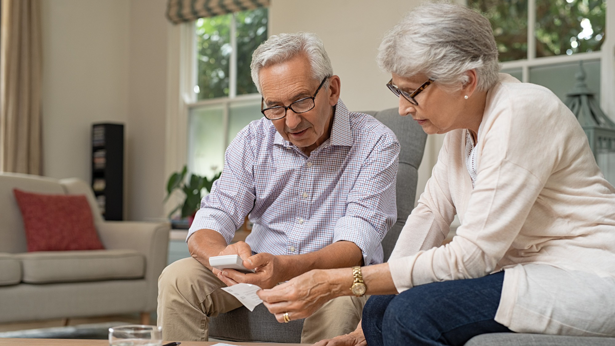 Elderly couple sit together.