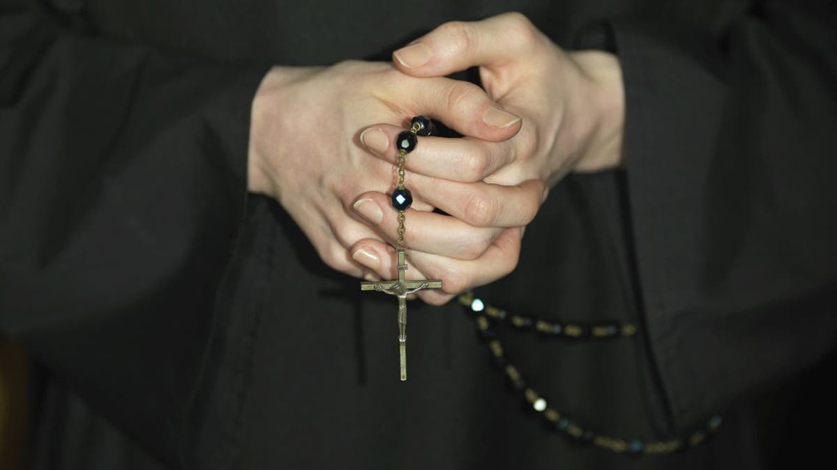 Close-up on a nun's hands holding a rosary