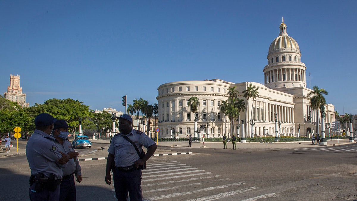 Police stand guard near the National Capitol building in Havana, Cuba.