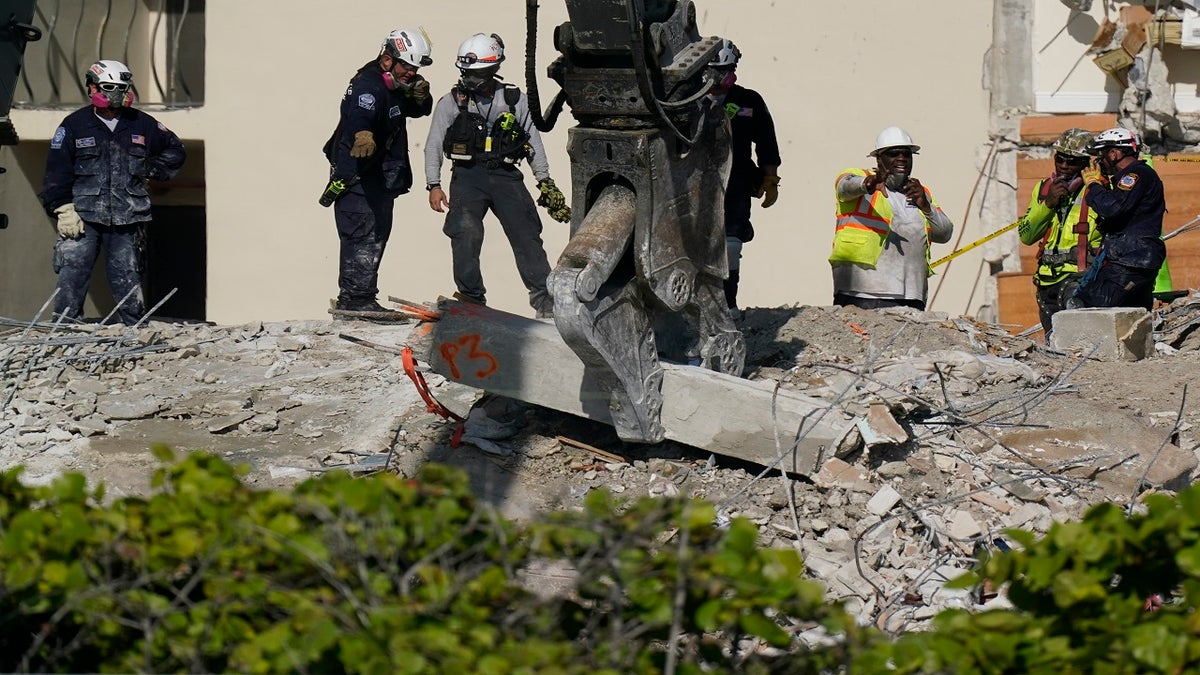 Heavy machinery is used to remove a support column as search and rescue personnel work atop the rubble at the Champlain Towers South condo building on Friday. (AP)