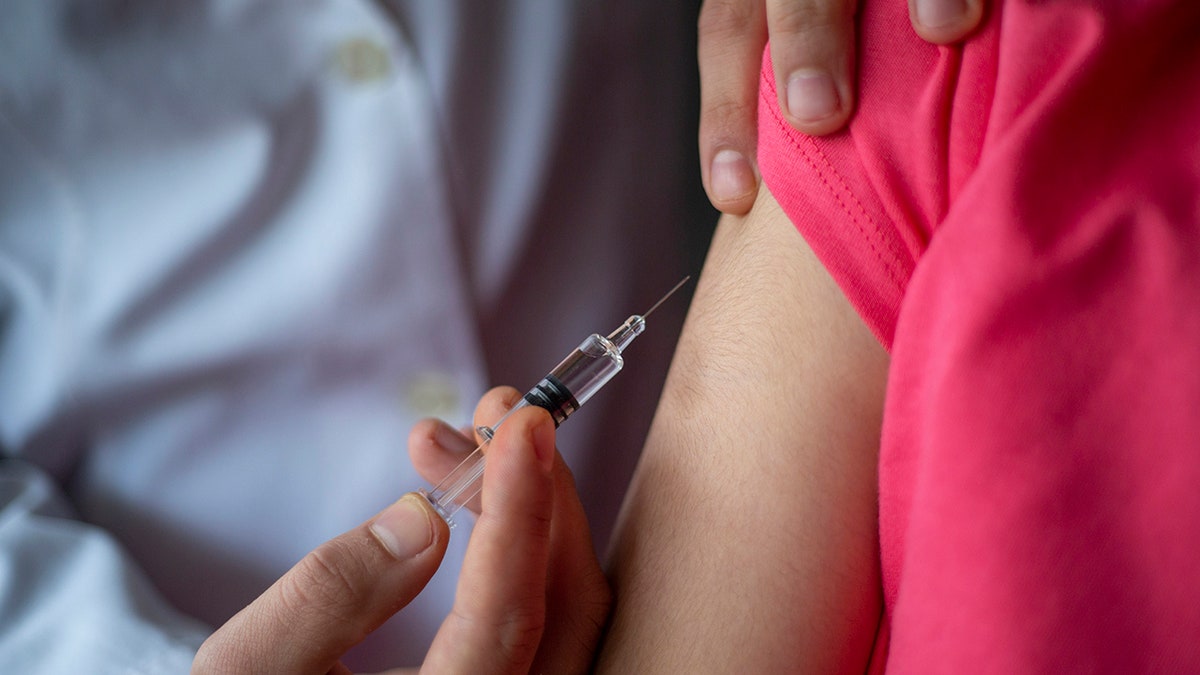 Doctor giving child patient injection