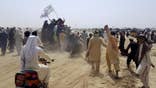 Supporters of the Taliban carry the Taliban's signature white flags in the Afghan-Pakistan border town of Chaman, Pakistan, Wednesday, July 14, 2021. The Taliban are pressing on with their surge in Afghanistan, saying Wednesday that they seized Spin Boldaka, a strategic border crossing with Pakistan, the latest in a series of key border post to come under their control in recent weeks. (AP Photo/Tariq Achkzai)