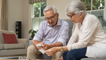 Elderly couple sit together.