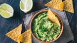 Bowl of guacamole with tortilla chips: top view