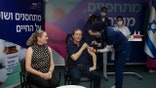 Israeli President Isaac Herzog receives a third coronavirus vaccine injection while his wife, Michal, left, reacts, at the Sheba Medical Center in Ramat Gan, Israel, Friday, July 30, 2021. (AP Photo/Maya Alleruzzo, Pool)