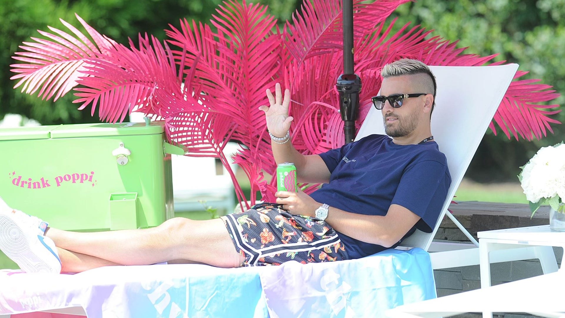 Scott Disick waves at girlfriend Amelia Gray and his three kids while sipping poppi prebiotic soda poolside at The Poppi House in the Hamptons on July 15, 2021.