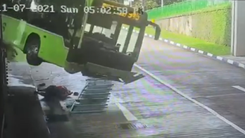 Driver narrowly escapes being crushed by falling bus