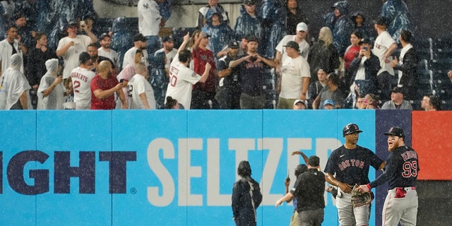 Boston Red Sox first baseman Tom Goodwin, second from left, calms outfielder Alex Verdugo (99) after being hit in the back by an object thrown by a fan in the sixth inning of 'baseball game against the New York Yankees on Saturday, July 17, 2021, in New York City.  (AP Photo / Marie Altaffer)